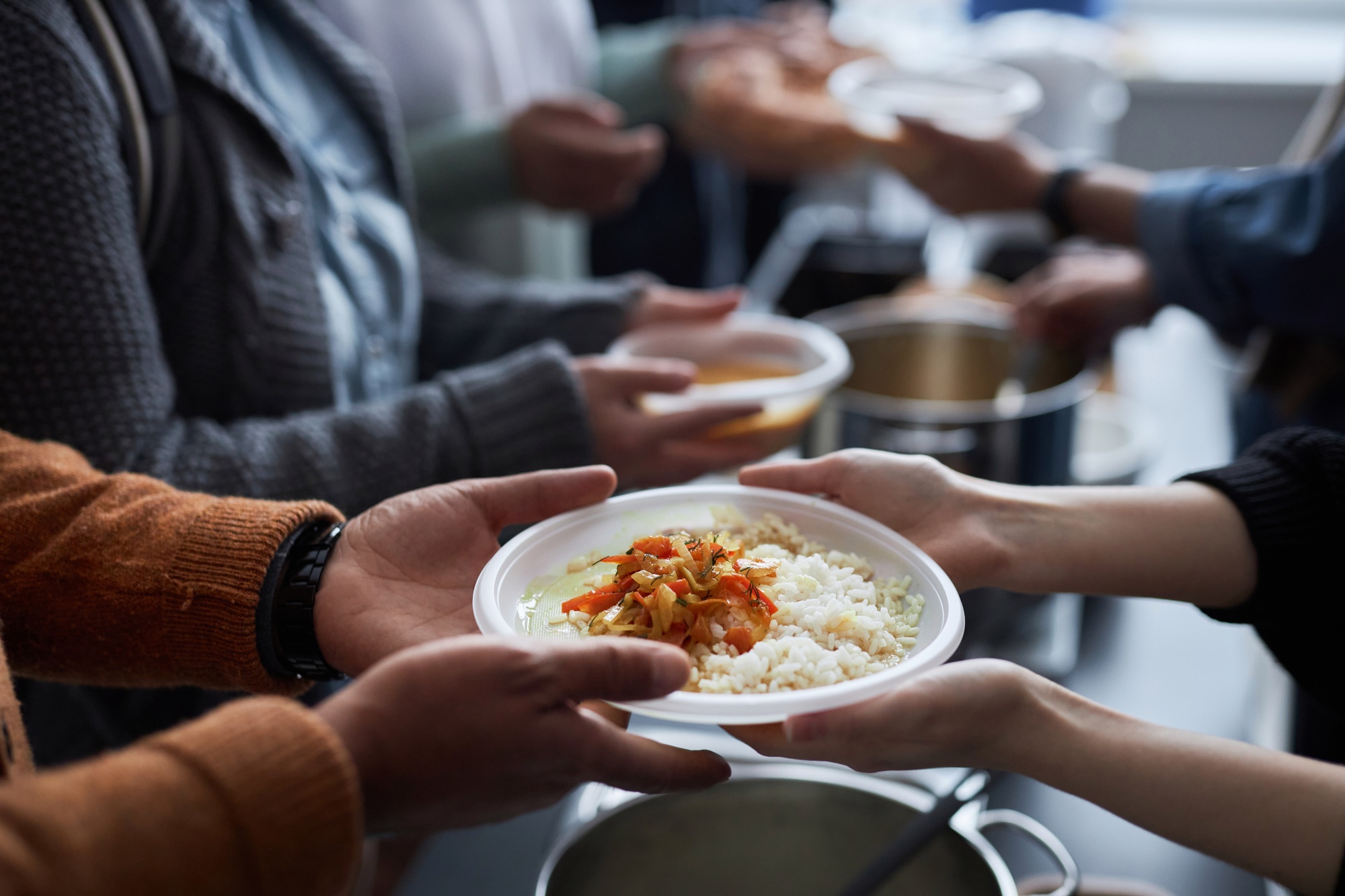 Volunteer Helping Refugees at Soup Kitchen